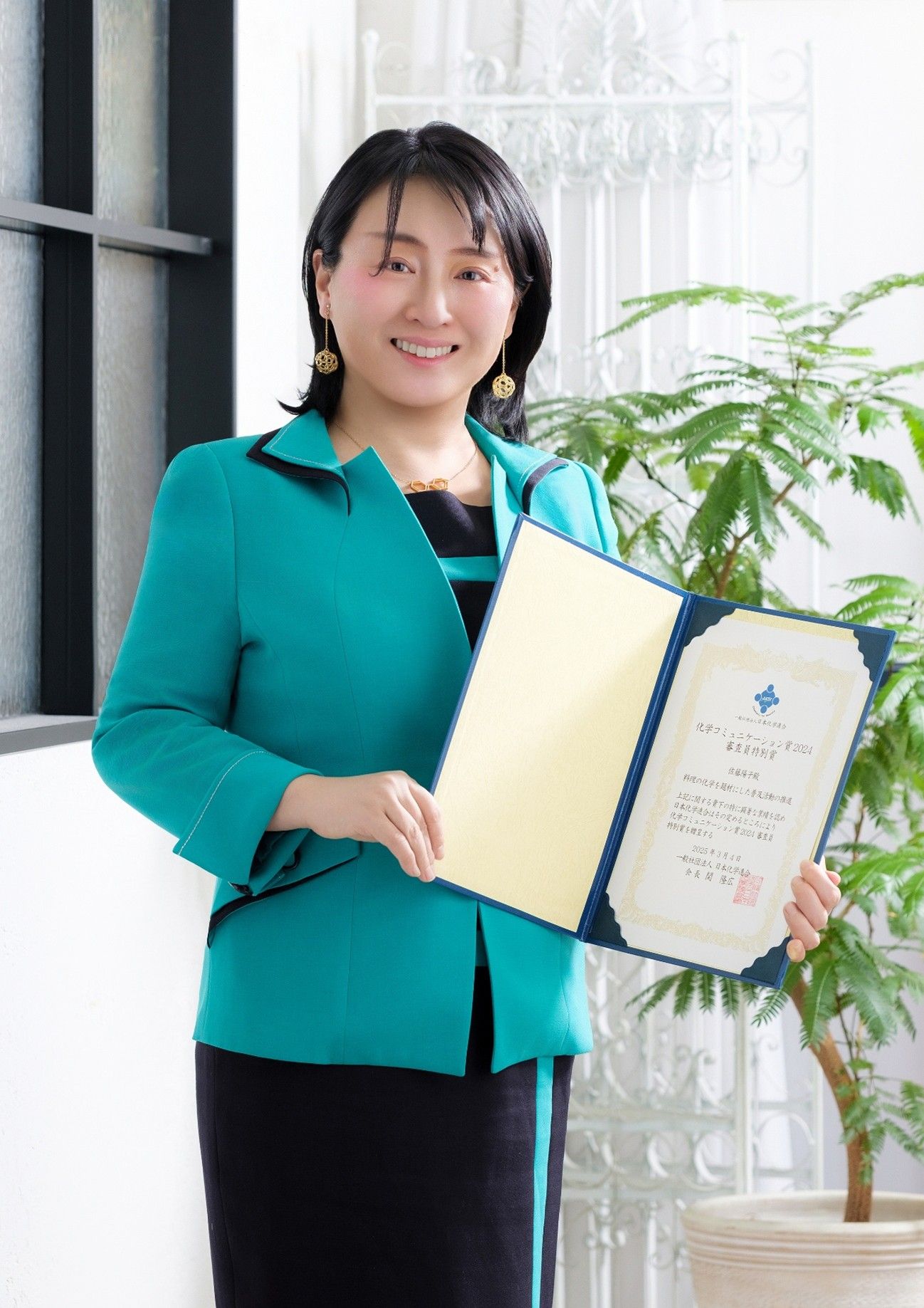 化学コミュニケーション賞2024の賞状を持つ佐藤先生